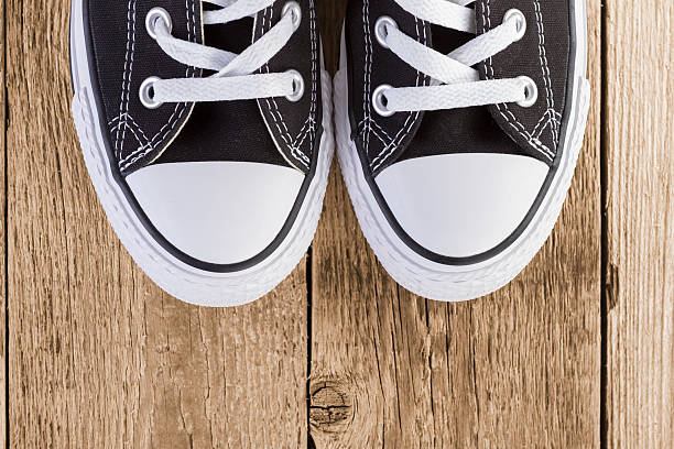 istock Black sneakers on wood background 513548374