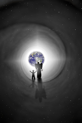 The silhouette of an angel holding the hand of a child as she walks him back to earth in this reincarnation concept image.  Earth and stars provided by NASA.