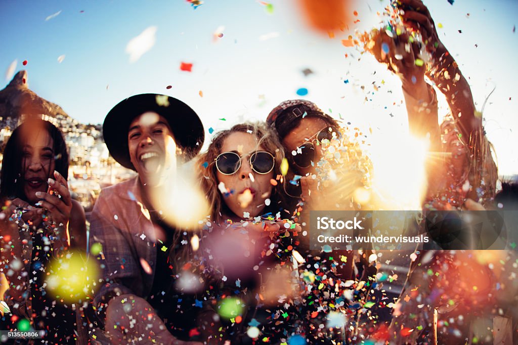 Adolescente hipster amigos de fiesta por soplado colorido confeti de manos - Foto de stock de Fiesta libre de derechos