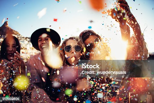 istock Teenager hipster friends partying by blowing colorful confetti from hands 513550806
