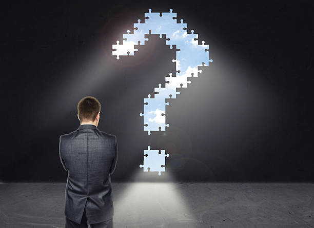 istock Businessman standing in front of the wall with big question 513553006