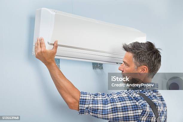 Male Technician Fixing Air Conditioner Stock Photo - Download Image Now - Adult, Air Conditioner, Blue-collar Worker