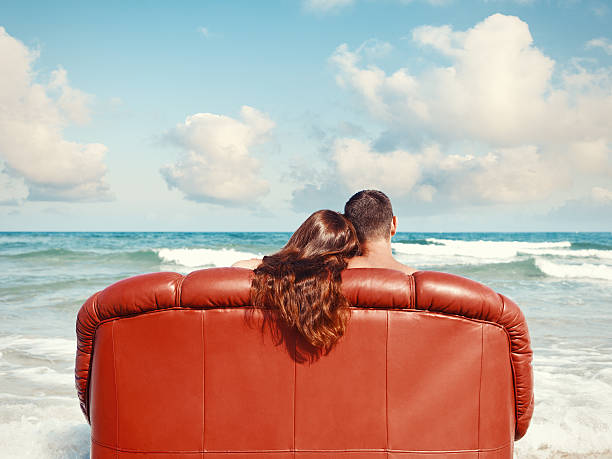 couple resting on the beach stock photo