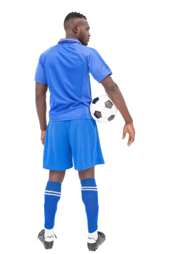 Rear view of a serious football player over white background