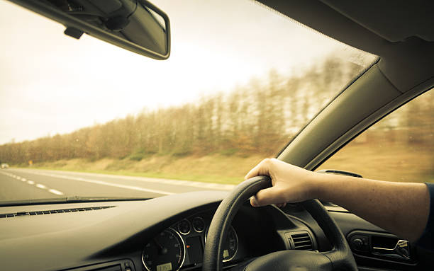 istock Male driver hands on steering wheel of a car 513568941