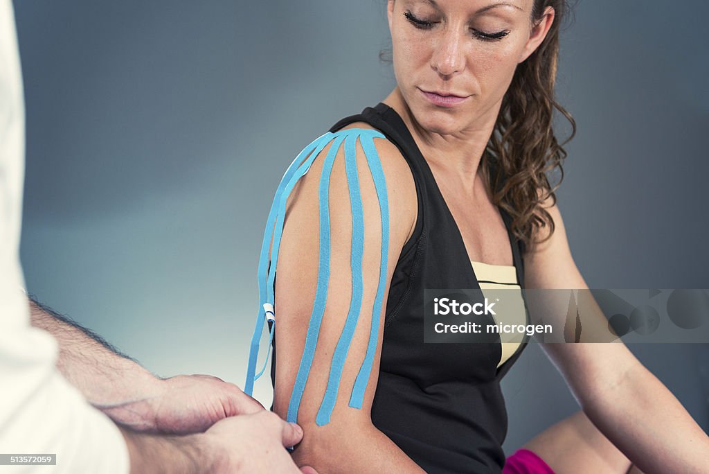 Treating shoulder with kinesio tape Therapeutic treatment of shoulder with kinesio tape Adhesive Tape Stock Photo
