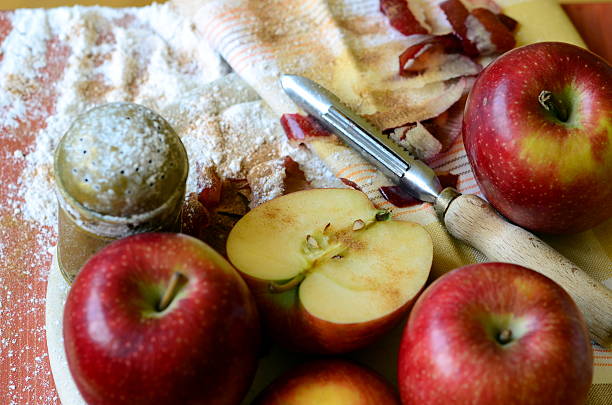 istock Apples, peeler, sugar shaker and tea towel on chopping board 513582218