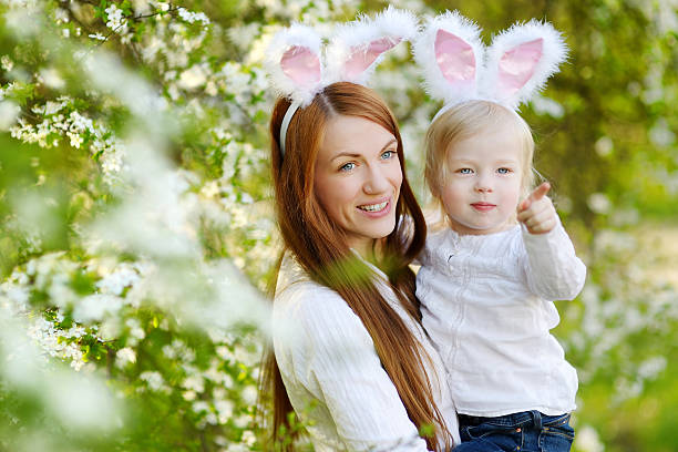 istock Mother and daughter wearing bunny ears on Easter 513582388