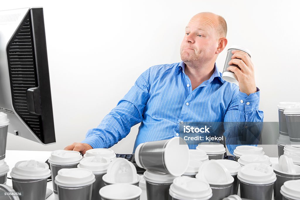 Hardworking business man drinks too much coffee Overworked and exhausted office worker or businessman high on coffeine. Man drinks too much coffee. Coffee - Drink Stock Photo
