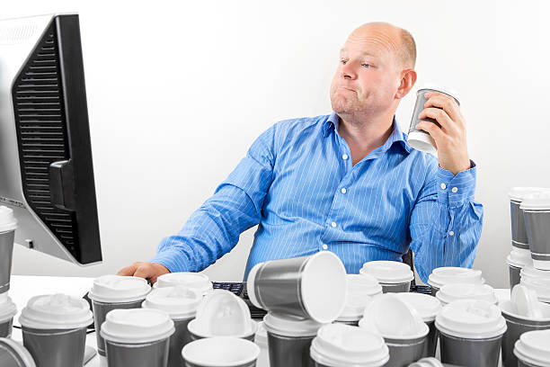 Hardworking business man drinks too much coffee Overworked and exhausted office worker or businessman high on coffeine. Man drinks too much coffee. coffee addict stock pictures, royalty-free photos & images