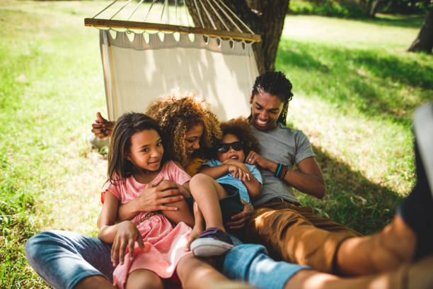 привлекательные афро-американской семьи, проводить время с семьей в bea - family grass toddler african descent стоковые фото и изображения