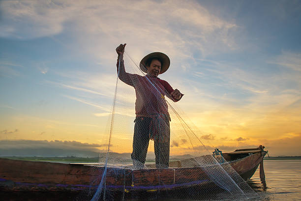 Fisherman fishing at lake in Morning, Thailand. Fisherman fishing at lake in Morning, Thailand. entrapment stock pictures, royalty-free photos & images