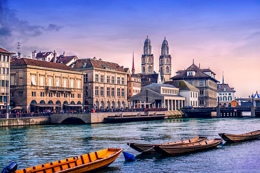 Beautiful Zurich Cityscape. Grossmunster Cathedral with River Limmat, traditional Swiss buildings at sunset. Zurich, Switzerland.