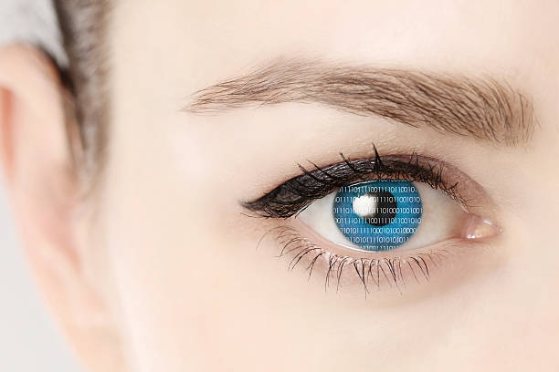 istock Close up of blue eye of woman showing binary codes 513589426