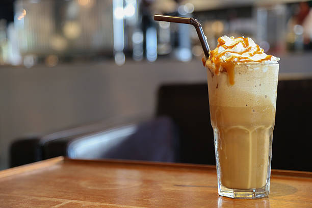 Caramel Cappuccino hits coffee Caramel frappe coffee on brown wood table with space in the coffee shop. milkshake stock pictures, royalty-free photos & images