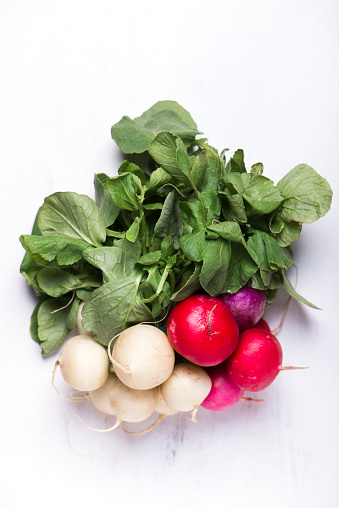 bunch of organically grown, freshly harvested, colourful Easter egg radishes, isolated over white board, close up