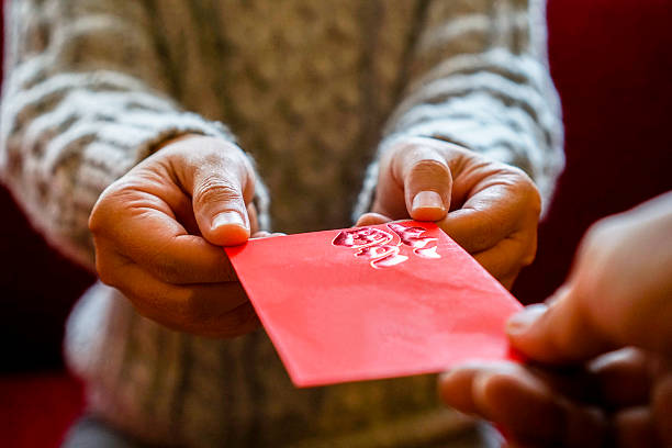 предоставление красный конверт для денег на отдых - hongbao стоковые фото и изображения