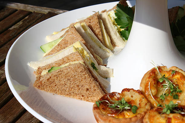 istock Afternoon tea / cream tea, white tiered cake stand, sandwiches, mini-quiches 513602801