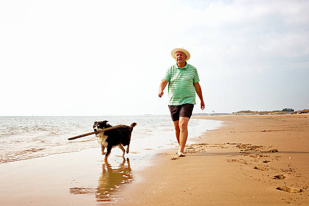istock Mature man walking on the seashore with his dog 513603159