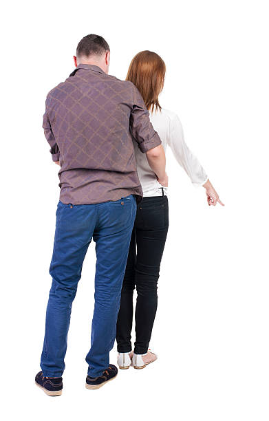 young couple pointing. young couple pointing. Back view.  Rear view people collection.  backside view of person.  Isolated over white background. man touching womans buttock stock pictures, royalty-free photos & images