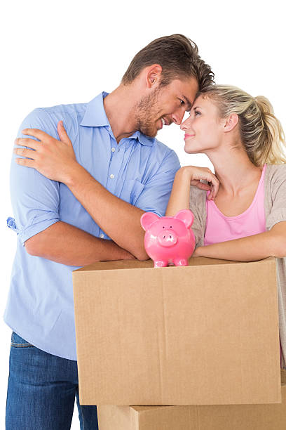 istock Couple with piggybank over cardboard box 513605579