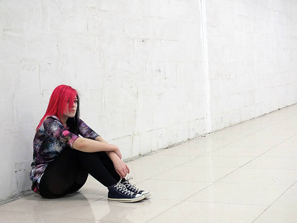 Sad girl sitting on the floor sad girl sitting on the floor against a white wall black hair emo girl stock pictures, royalty-free photos & images