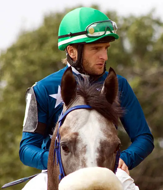 A jockey  riding a horse before a race for the prize Derby.