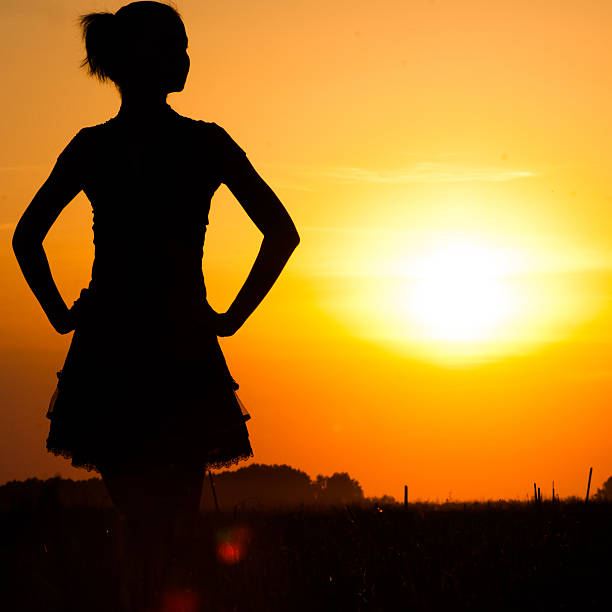 istock young woman silhouette at sunset 513631398