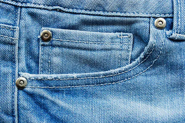 Jeans front pocket with metal rivets as a background