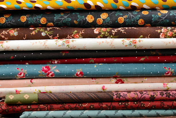 istock heap of cloth fabrics on wooden table 513632621