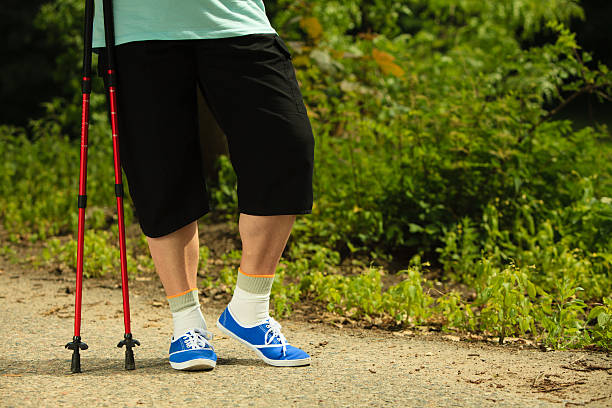 istock active senior legs in sneakers nordic walking in a park. 513633307