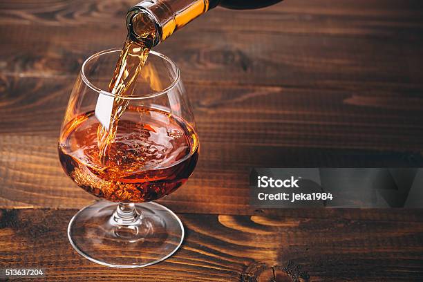 Pouring Cognac Or Whiskey From The Bottle Stock Photo - Download Image Now - Activity, Alcohol - Drink, Bar - Drink Establishment