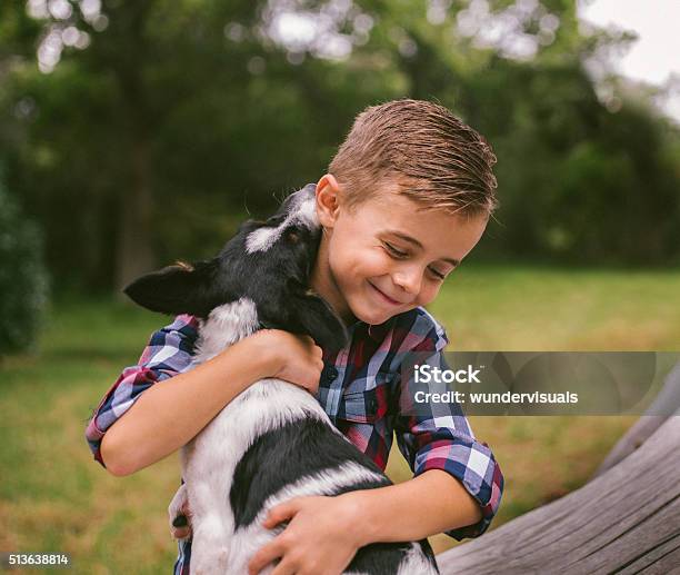 Closeup Cute Rascal Boy Gives His Puppy A Big Hug Stock Photo - Download Image Now - Dog, Child, Boys