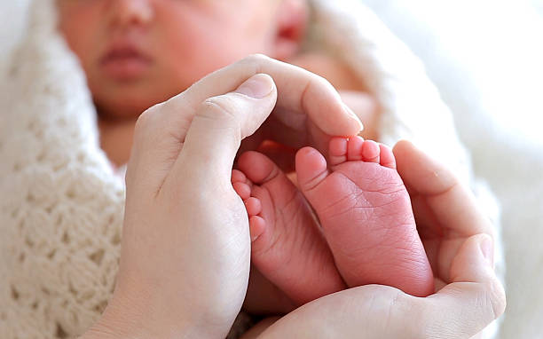 istock Baby Feet In Mother Hands 513640972