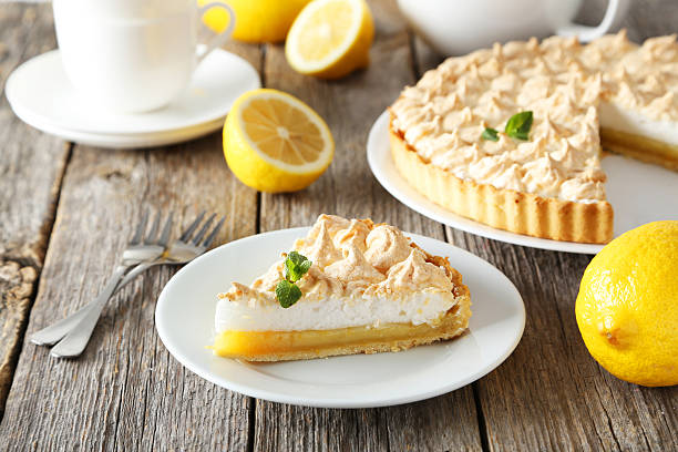 Lemon meringue pie on plate on grey wooden background