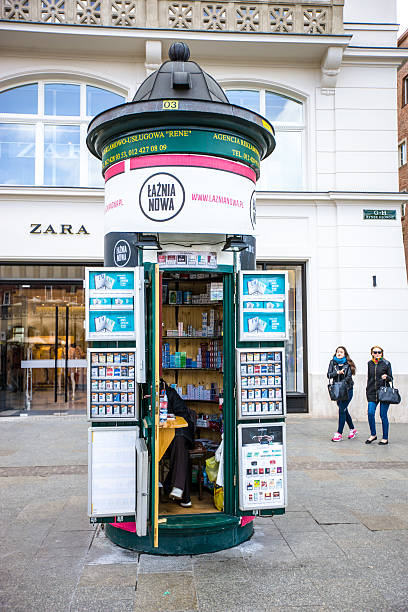 Krakow, Poland- April 29, 2015: Kiosk selling cigarettes on Krakow Street. Few people on the street, vendor inside the kiosk.