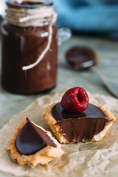 istock Mini pastry tartlets with chocolate, on old paper 513642762