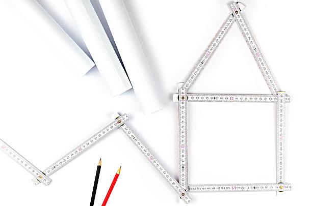 white meter tool forming a house white meter tool forming a house, two drawing pencils and paper drawings on white background turnkey project stock pictures, royalty-free photos & images