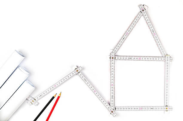 white meter tool forming a house white meter tool forming a house, two drawing pencils and paper drawings on white background turnkey project stock pictures, royalty-free photos & images