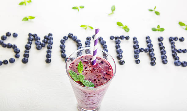 heidelbeer-smoothie in glas mit stroh - blueberry smoothie glass striped stock-fotos und bilder