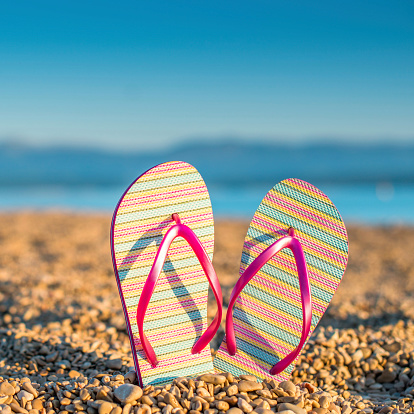 Close up of a pair of flip flop on the seaside.