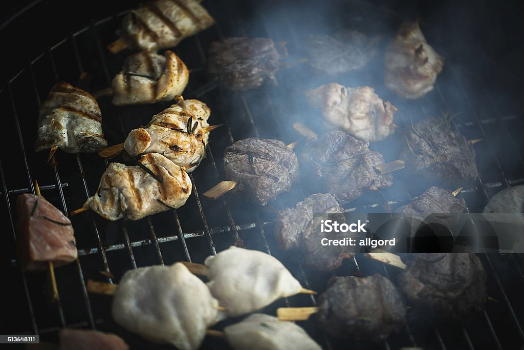 Pieces of meat on the grill Fresh meat preparing on grill Barbecue - Meal Stock Photo