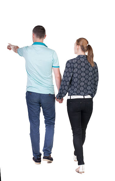istock Back view of walking young couple (man and woman) pointing. 513649729