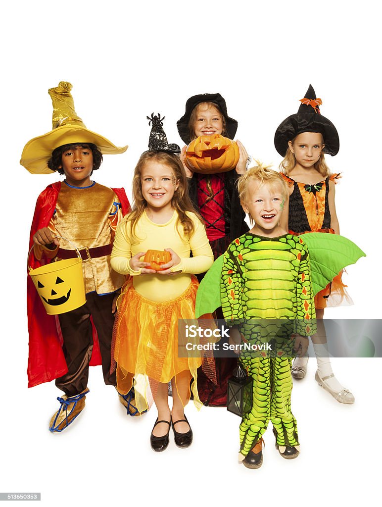 Kids with pumpkin and in Halloween costumes Five happy boys and girls standing together wearing Halloween costumes, pumping and bucket for candies , isolated on white African Ethnicity Stock Photo