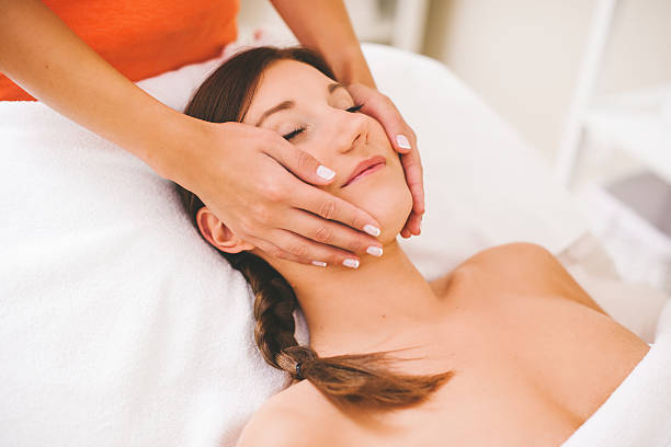 frau immer einer spa-behandlung gesicht massage - head massage flash stock-fotos und bilder