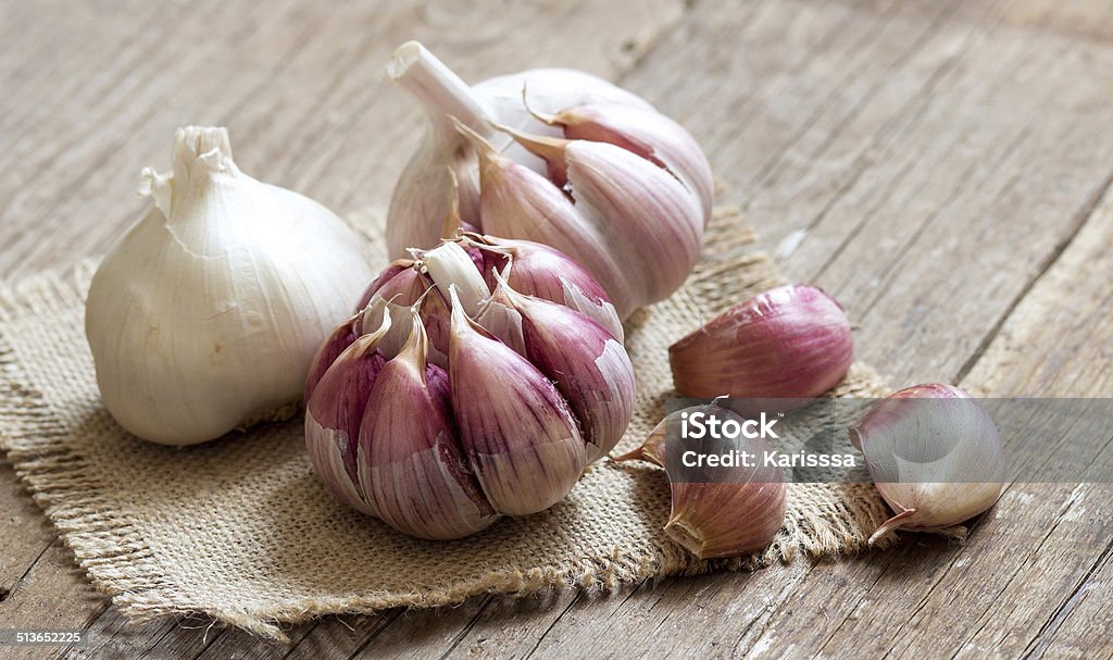 Fresh garlic on wooden background Whole and split fresh garlic on wooden background Garlic Stock Photo