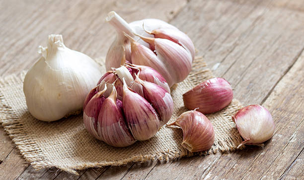 Fresh garlic on wooden background Whole and split fresh garlic on wooden background garlic clove photos stock pictures, royalty-free photos & images