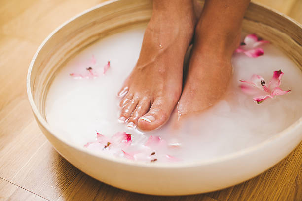 Feet in a foot bath with milk stock photo