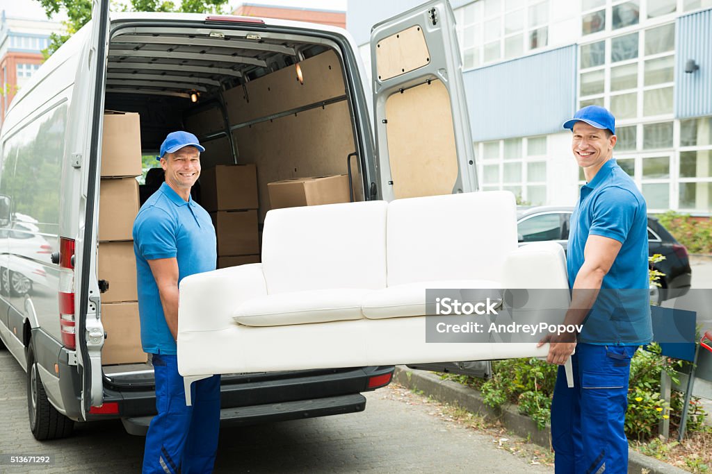 Workers Putting Furniture And Boxes In Truck Two Happy Male Workers Putting Furniture And Boxes In Truck Delivering Stock Photo