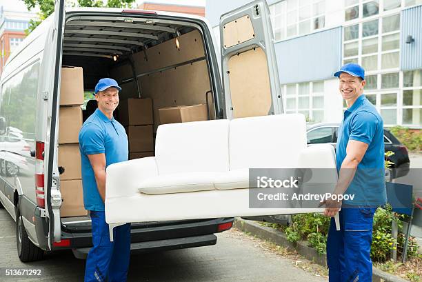 Workers Putting Furniture And Boxes In Truck Stock Photo - Download Image Now - Delivering, Furniture, Sofa